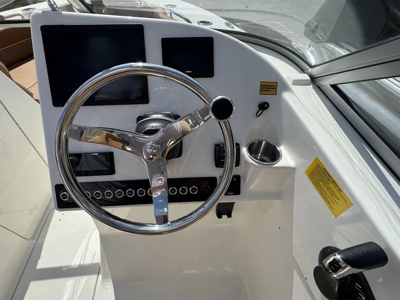 Slide: The Image of 2025 Key West 239 DFS boat dashboard with steering wheel and control panel. - 16