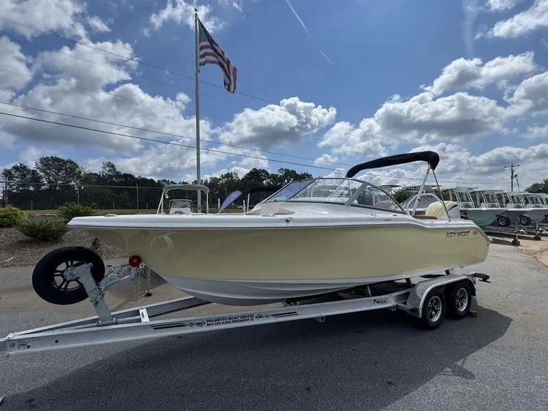 Slide: The Image of 2025 Key West 239 DFS boat on trailer, parked outdoors under a cloudy sky. - 4