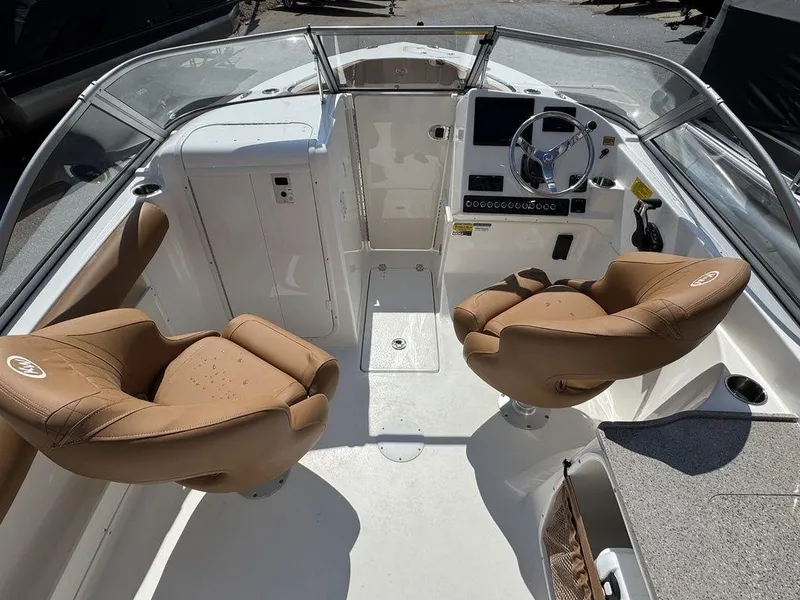 Slide: The Image of 2025 Key West 239 DFS boat interior with tan seats and modern dashboard. - 9