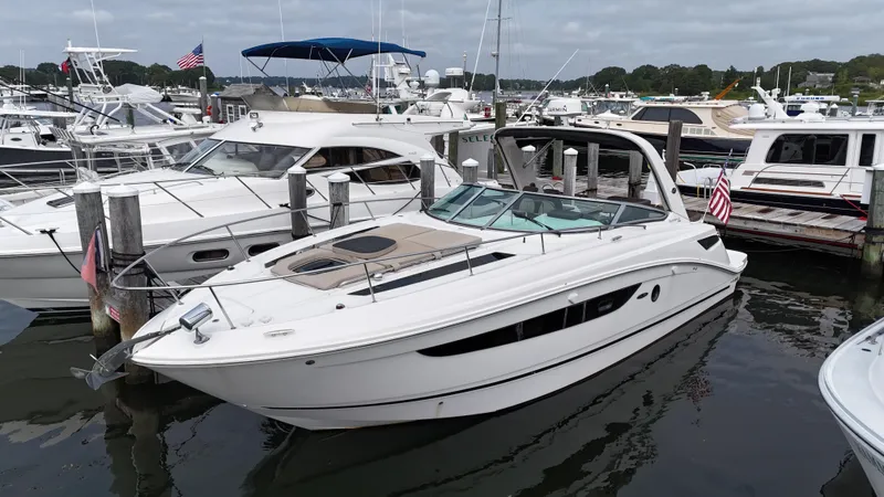 Slide: The Image of 2014 Sea Ray 350 Sundancer docked at marina, surrounded by other boats. - 0