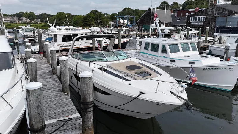 Slide: The Image of 2014 Sea Ray 350 Sundancer docked at a marina with other boats. - 1