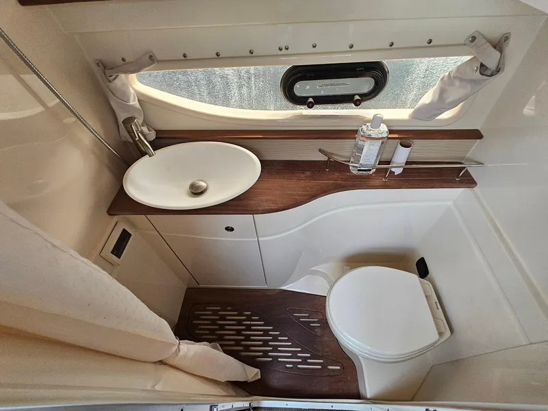 Slide: The Image of 2014 Sea Ray 350 Sundancer bathroom with sink, toilet, and window. - 16