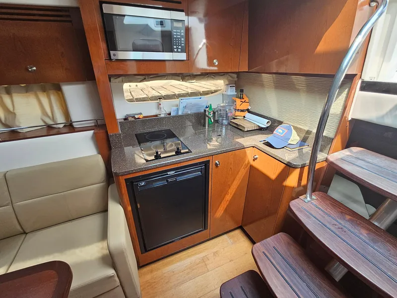 Slide: The Image of Interior of 2014 Sea Ray 350 Sundancer yacht kitchen with microwave, stove, and fridge. - 17