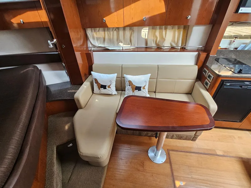 Slide: The Image of Luxurious interior of 2014 Sea Ray 350 Sundancer with beige seating and wooden table. - 18