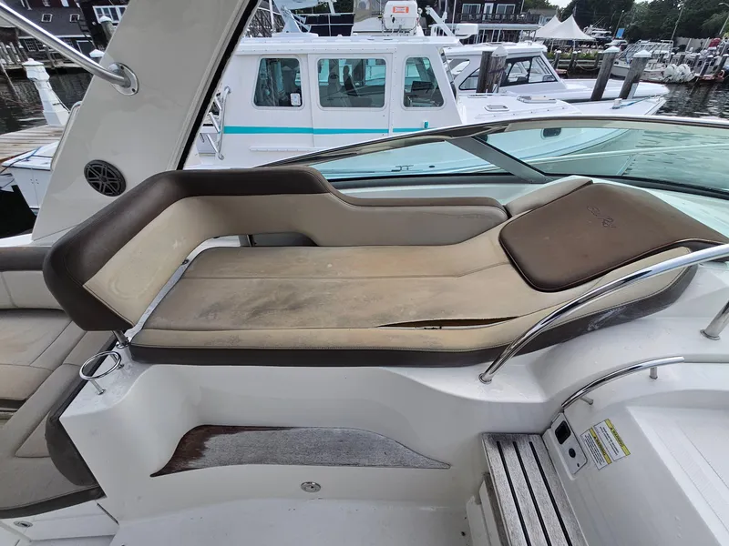 Slide: The Image of 2014 Sea Ray 350 Sundancer boat interior with cushioned seating and sleek design. - 8