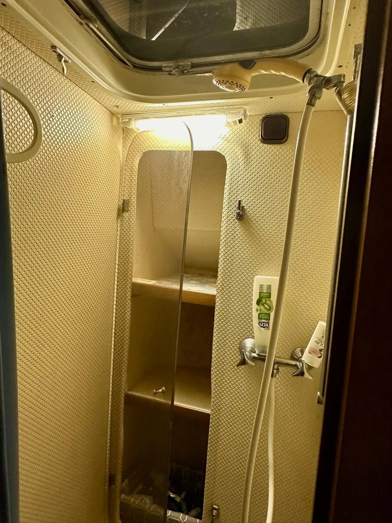 Slide: The Image of Shower area inside 1986 Cytra Bavaria 40 yacht, featuring a compact design and overhead lighting. - 18