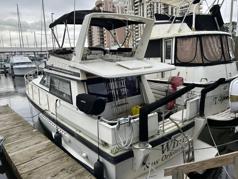 Slide: The Image of 1986 Cytra Bavaria 40 yacht docked at marina, featuring spacious deck and covered cockpit. - 2