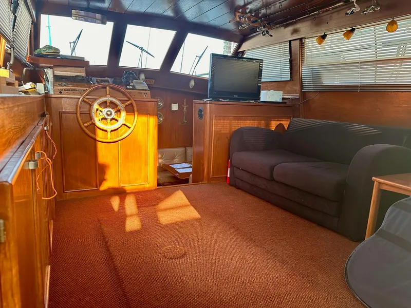 Slide: The Image of Interior of 1986 Cytra Bavaria 40 yacht with wooden helm and cozy seating area. - 8