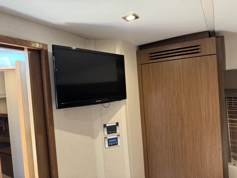 Slide: The Image of Interior of 2017 Sea Ray Sundancer 460 yacht with wall-mounted TV and wooden cabinetry. - 12