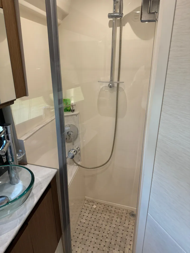 Slide: The Image of Shower area in 2017 Sea Ray Sundancer 460 yacht, featuring modern fixtures and glass door. - 17