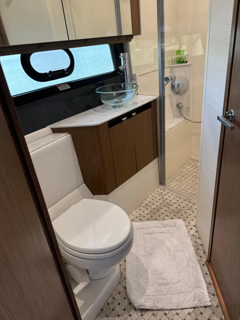 Slide: The Image of 2017 Sea Ray Sundancer 460 bathroom with modern fixtures and glass sink. - 19