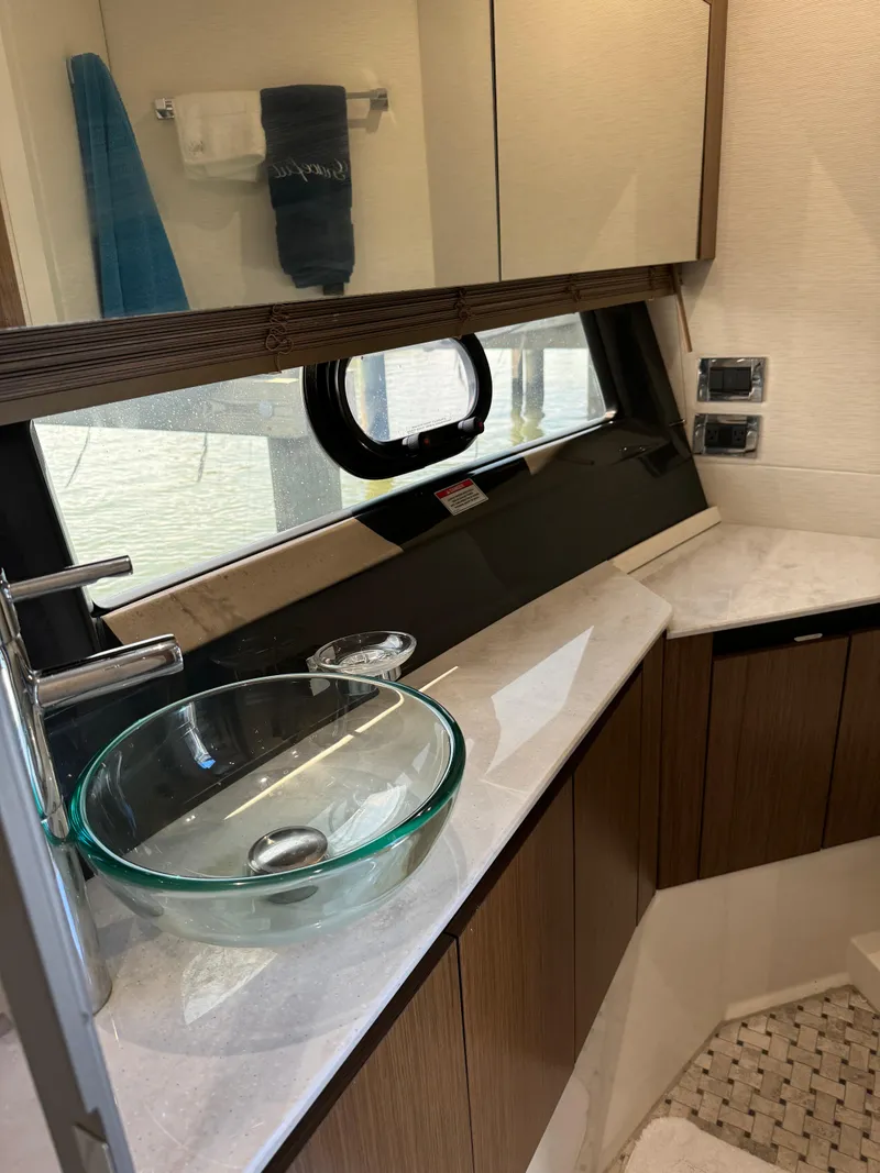 Slide: The Image of 2017 Sea Ray Sundancer 460 bathroom with modern glass sink and wood cabinetry. - 21