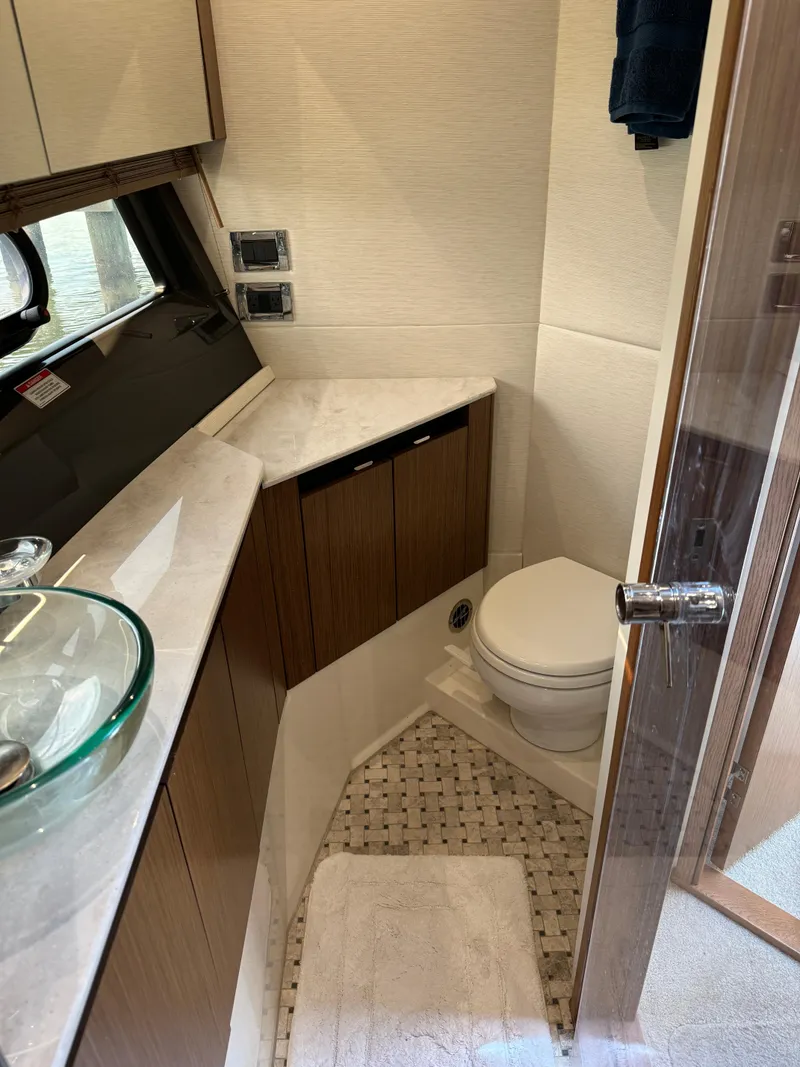 Slide: The Image of 2017 Sea Ray Sundancer 460 yacht bathroom with modern fixtures and wood cabinetry. - 22