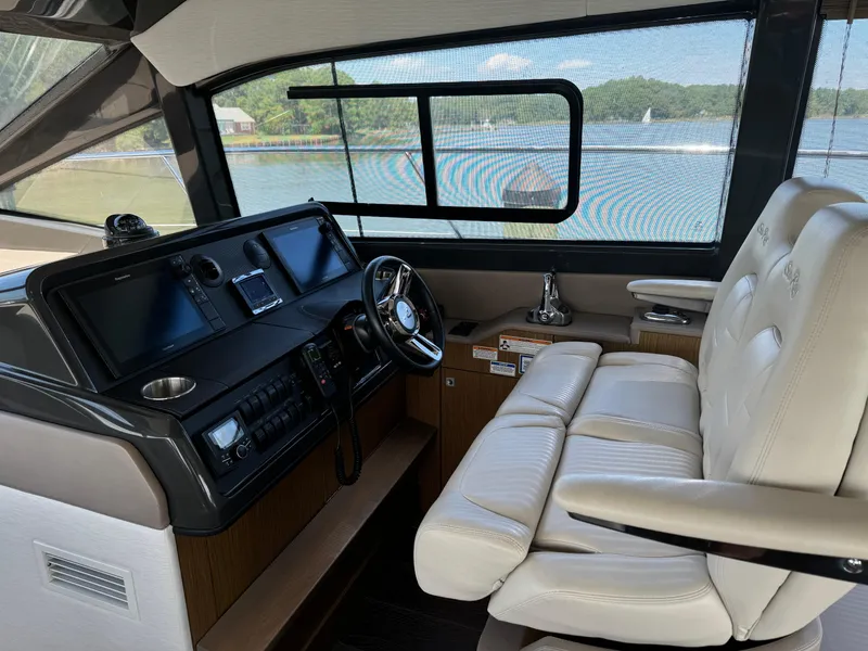 Slide: The Image of 2017 Sea Ray Sundancer 460 helm with leather seating and modern navigation controls. - 31