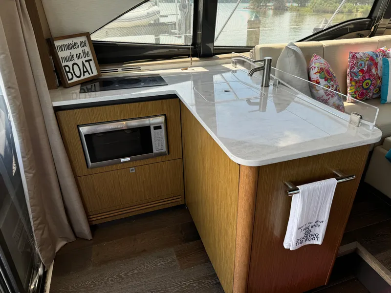 Slide: The Image of Modern kitchen area in a 2017 Sea Ray Sundancer 460 yacht with microwave and sink. - 40
