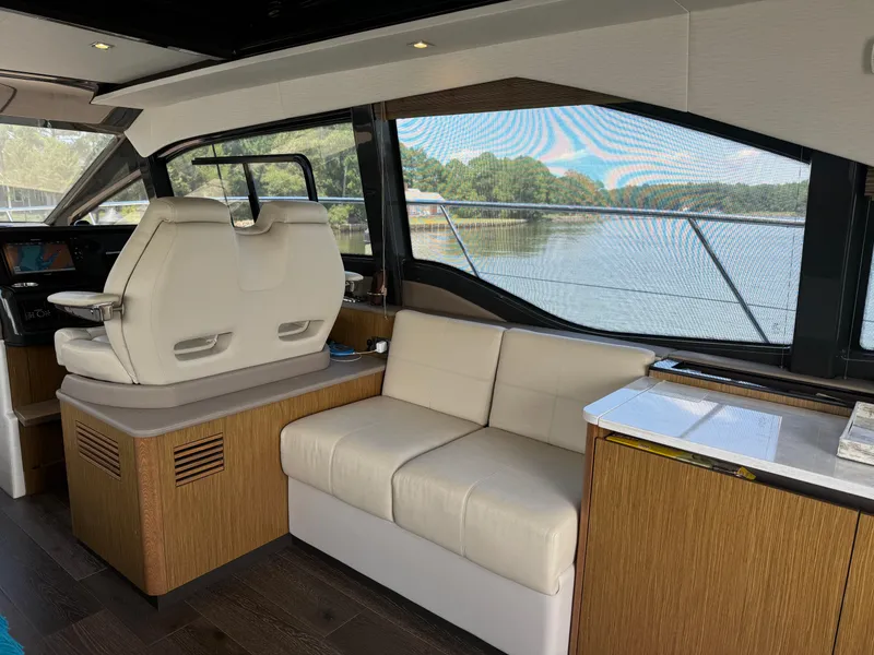 Slide: The Image of Interior of 2017 Sea Ray Sundancer 460 yacht with modern seating and scenic window view. - 42