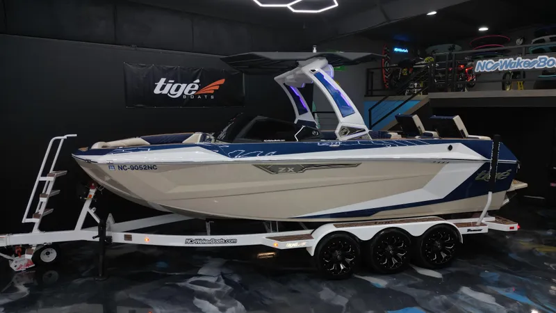 Slide: The Image of 2024 Tigé Ultré 23ZX boat on trailer in showroom. - 2