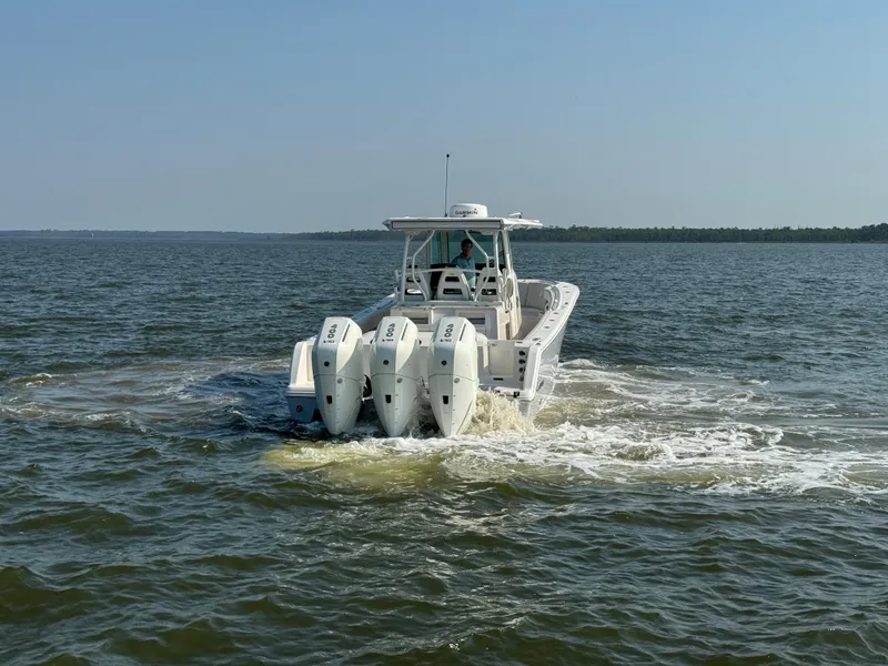 Slide: The Image of 2024 Sailfish 360 CC boat cruising on open water with triple engines. - 10