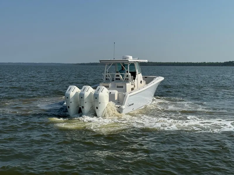 Slide: The Image of 2024 Sailfish 360 CC boat cruising on open water with triple engines. - 11