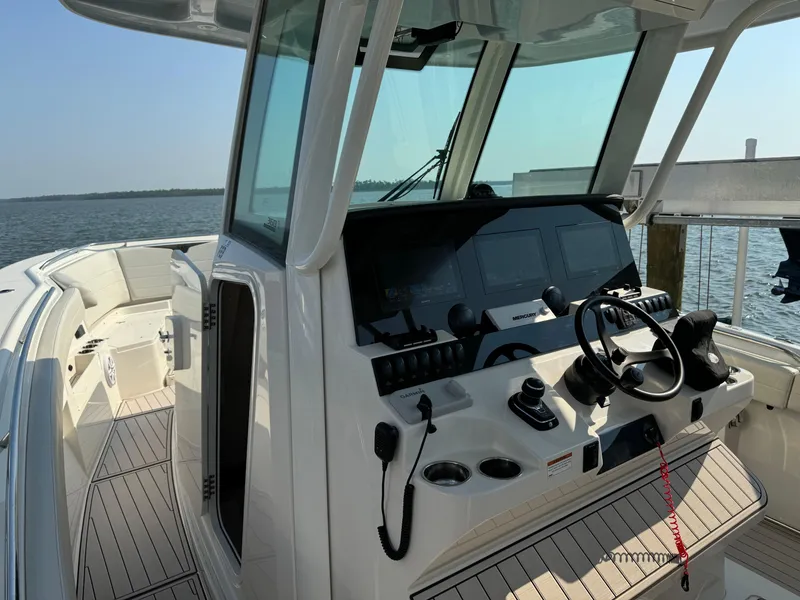 Slide: The Image of 2024 Sailfish 360 CC boat cockpit with modern controls and steering wheel. - 27