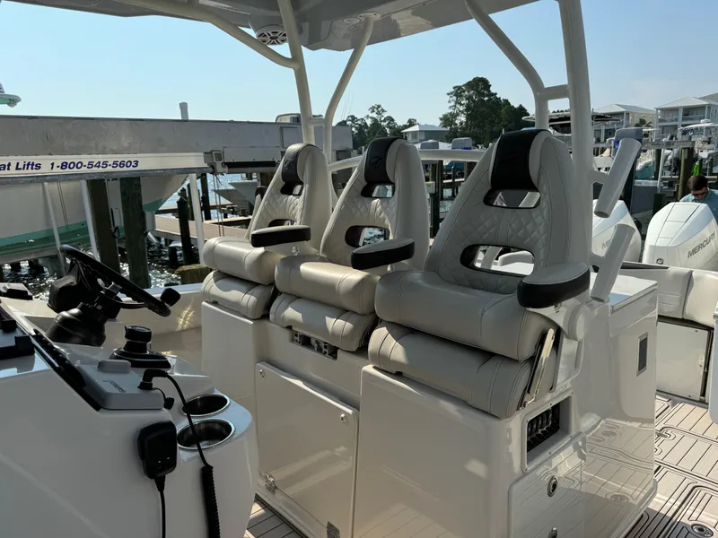 Slide: The Image of 2024 Sailfish 360 CC boat interior with three cushioned seats and steering console. - 30