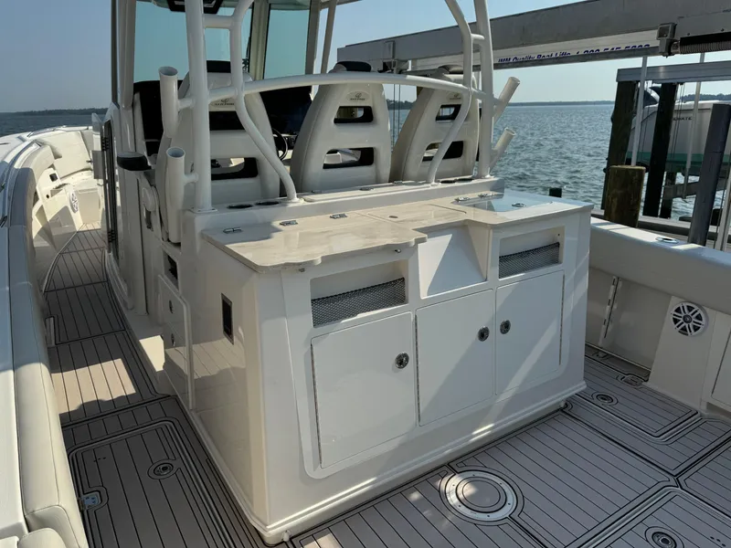 Slide: The Image of 2024 Sailfish 360 CC boat interior with seating and storage, docked by the water. - 33