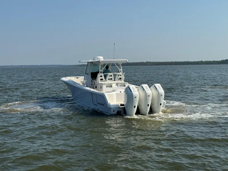 Slide: The Image of 2024 Sailfish 360 CC boat cruising on open water with triple engines. - 6