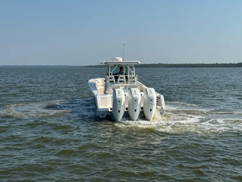 Slide: The Image of 2024 Sailfish 360 CC boat cruising on open water with triple outboard engines. - 8