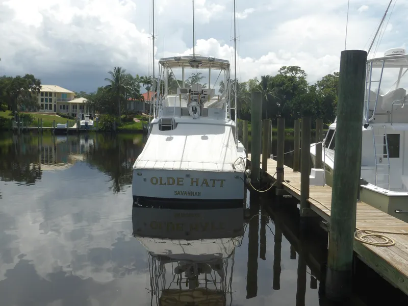 Slide: The Image of 1967 Hatteras Convertible boat docked, named "Olde Hatt," with scenic waterfront background. - 2