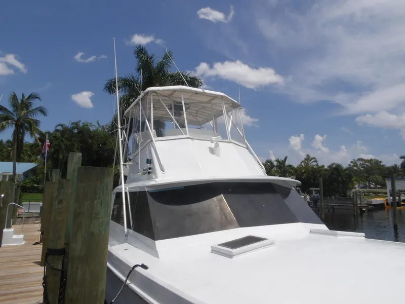 Slide: The Image of 1967 Hatteras Convertible yacht docked under a clear blue sky. - 24