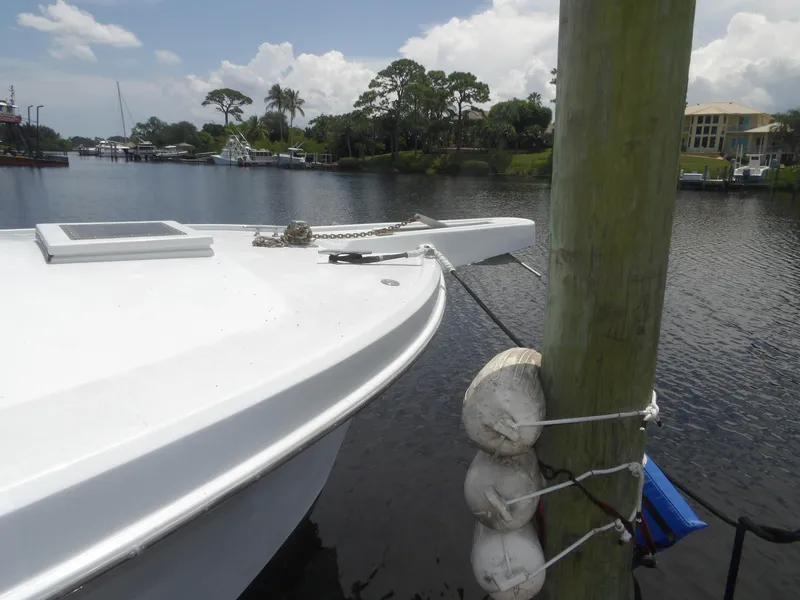 Slide: The Image of 1967 Hatteras Convertible boat docked by a wooden post on a calm river. - 26