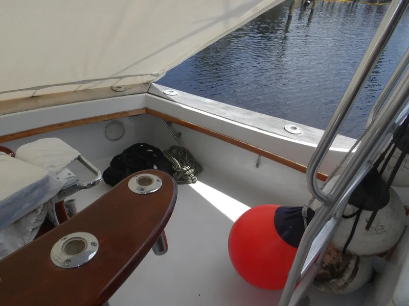 Slide: The Image of 1967 Hatteras Convertible boat deck with ropes, buoy, and seating by the water. - 30