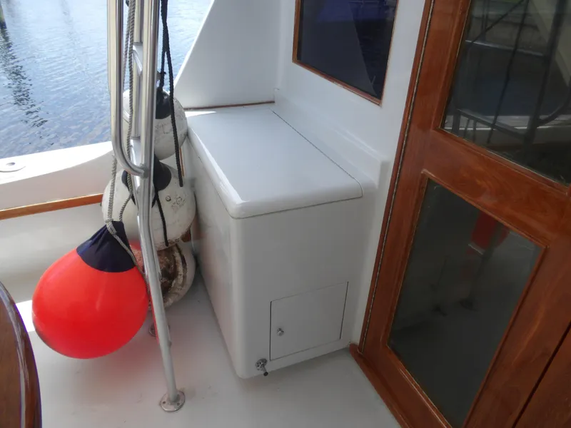 Slide: The Image of 1967 Hatteras Convertible boat deck with storage, fenders, and wooden door. - 32