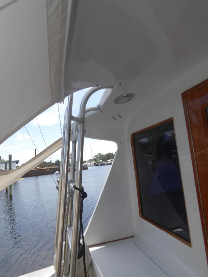Slide: The Image of 1967 Hatteras Convertible boat deck with water view and docked sailboat. - 33