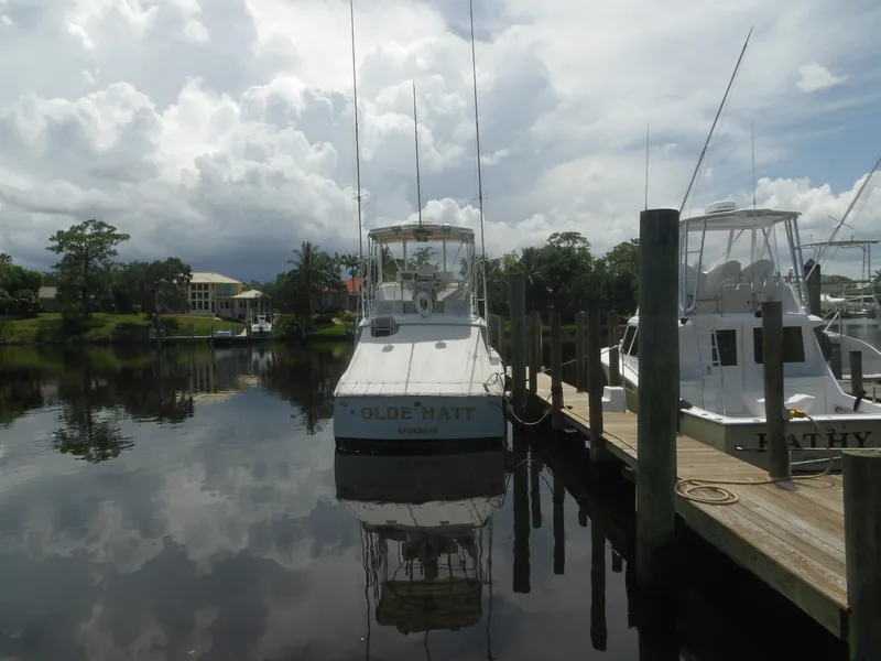 Slide: The Image of 1967 Hatteras Convertible boat docked at marina under cloudy sky. - 4