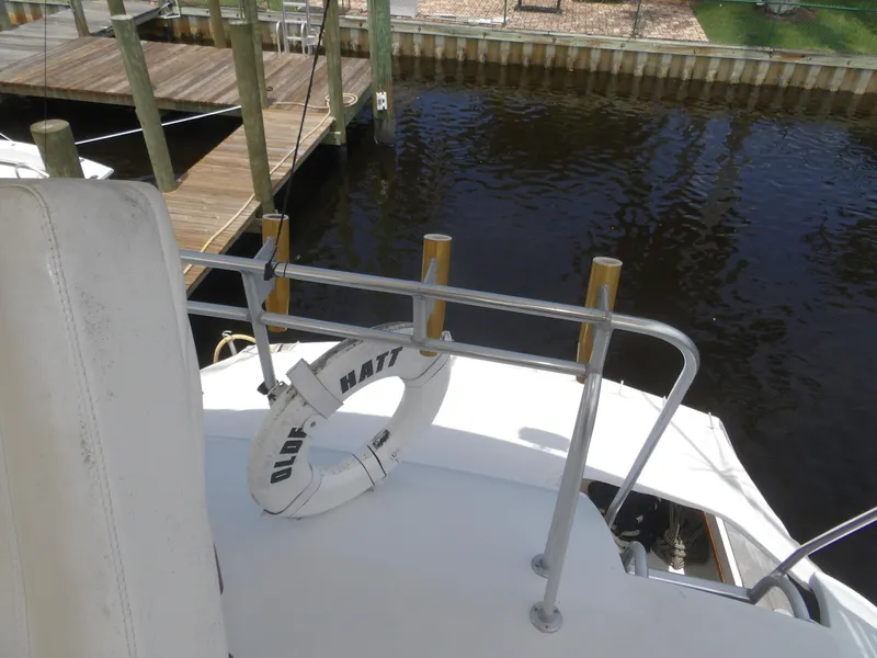 Slide: The Image of 1967 Hatteras Convertible boat with life ring docked by wooden pier. - 44