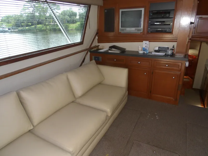 Slide: The Image of Interior of a 1967 Hatteras Convertible yacht with beige sofa and wooden cabinetry. - 46