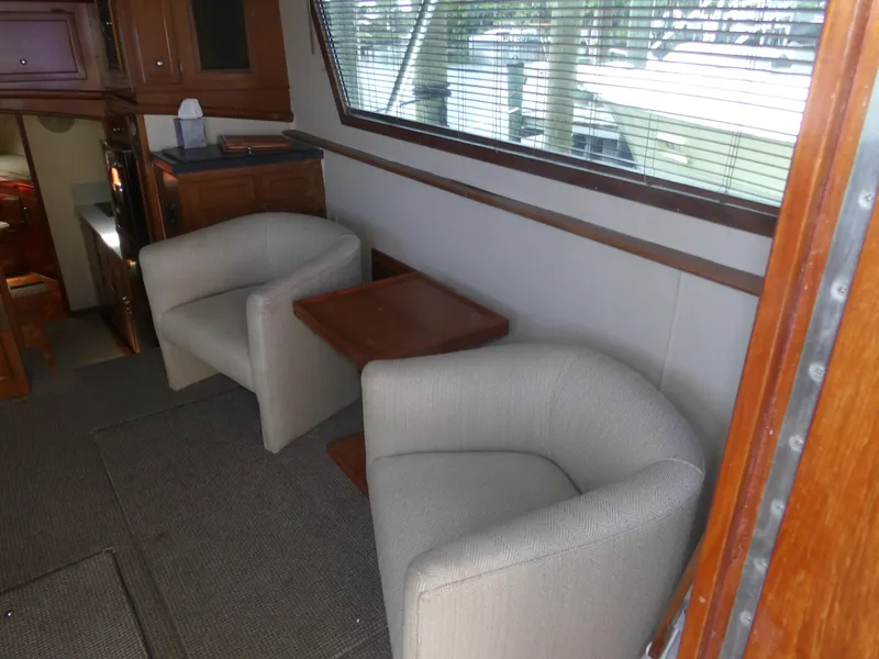 Slide: The Image of Interior of 1967 Hatteras Convertible yacht with two armchairs and a wooden table. - 47