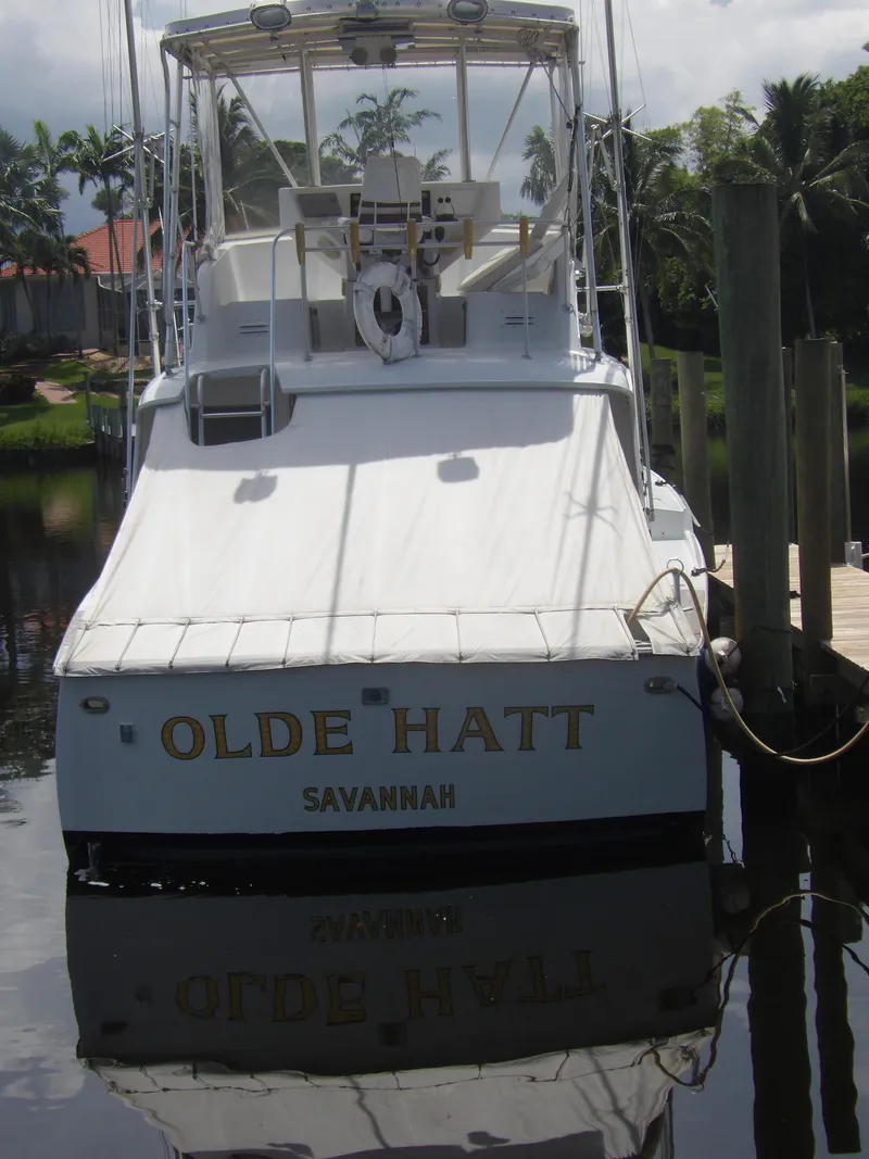 Slide: The Image of 1967 Hatteras Convertible boat named "Olde Hatt" docked in a marina. - 5