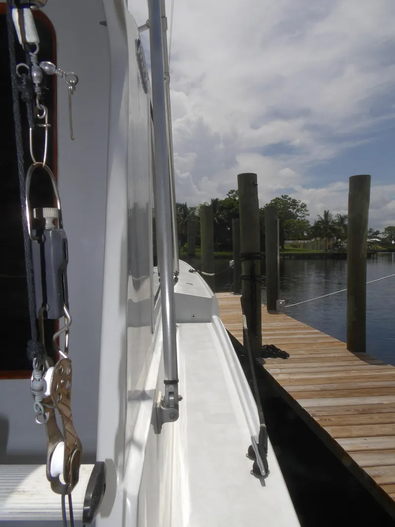 Slide: The Image of 1967 Hatteras Convertible yacht docked by a wooden pier under a cloudy sky. - 7