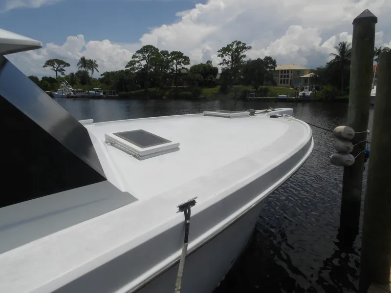 Slide: The Image of 1967 Hatteras Convertible boat docked on a calm river with lush greenery. - 8