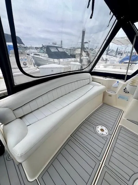 Slide: The Image of 2000 Rinker Fiesta Vee 342 boat interior with white seating and marina view. - 6