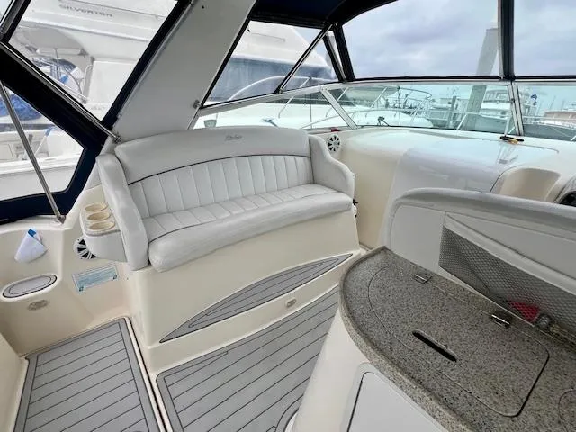 Slide: The Image of 2000 Rinker Fiesta Vee 342 boat interior with white seating and gray flooring. - 7
