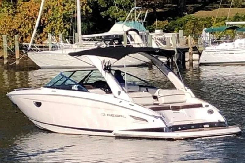 The Image of 2017 Regal 2800 boat on calm water near a marina. - 0