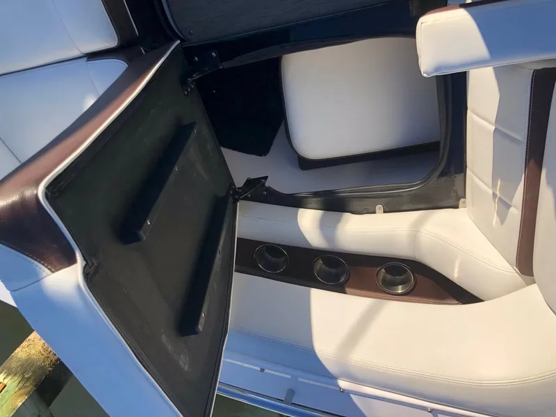 Slide: The Image of 2017 Regal 2800 boat interior with open storage compartment and cup holders. - 15