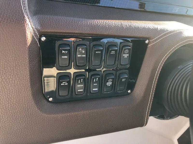 Slide: The Image of Control panel of a 2017 Regal 2800 boat with various switches. - 24
