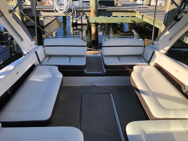 Slide: The Image of Spacious interior of 2017 Regal 2800 boat with white seating at dock. - 31