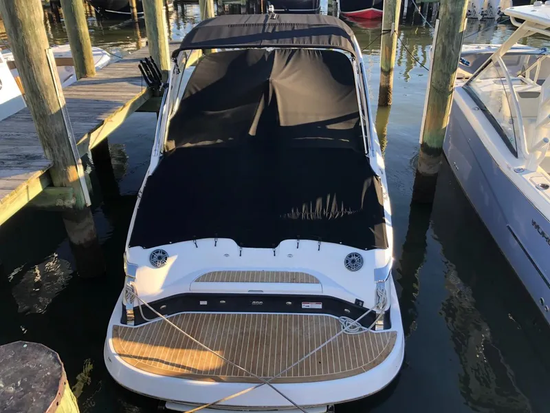 Slide: The Image of 2017 Regal 2800 boat docked with black cover, wooden deck, and marina setting. - 5