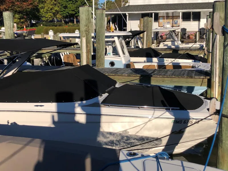 Slide: The Image of 2017 Regal 2800 boat docked at marina with black cover. - 6