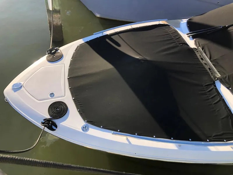 Slide: The Image of 2017 Regal 2800 boat with black cover docked on water. - 7